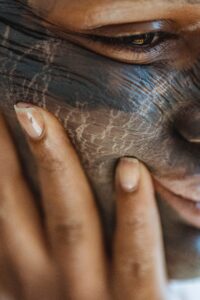 A lady rubbing a natural skin mask made from neem. Image- Pexels