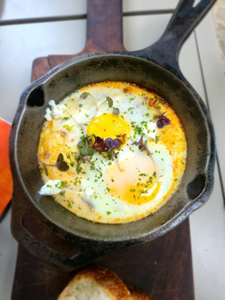 Shakshuka in a cast iron pan with edible flowers